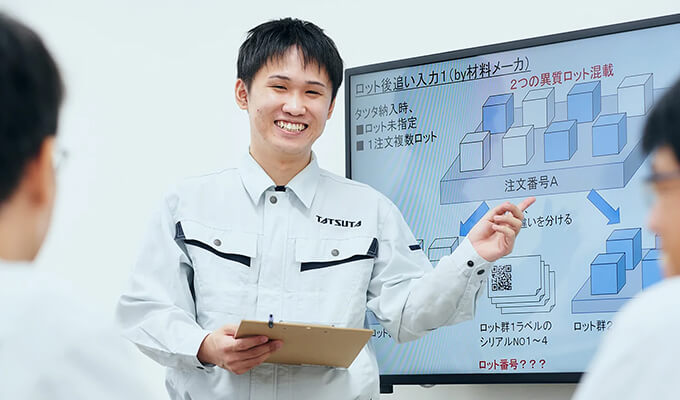 モニターで資料を説明する情報システム部の社員