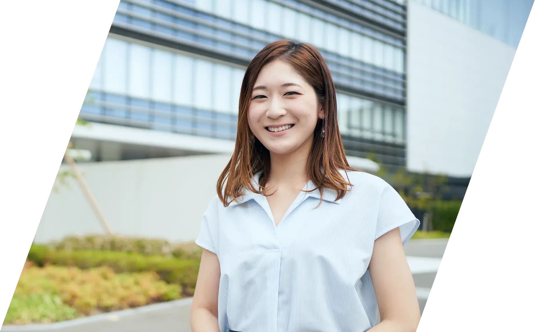 会社の前で笑顔を見せる総務人事部の社員