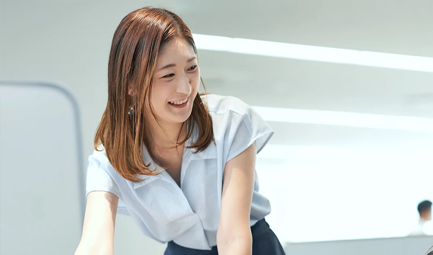 社内で同僚と打ち合わせをする総務人事部の社員
